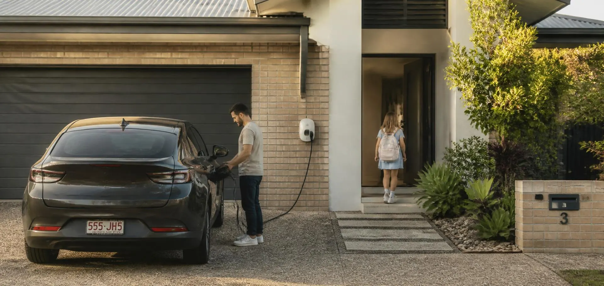 Family arriving home at a Gold Coast house in the late afternoon and plugging in their electric car